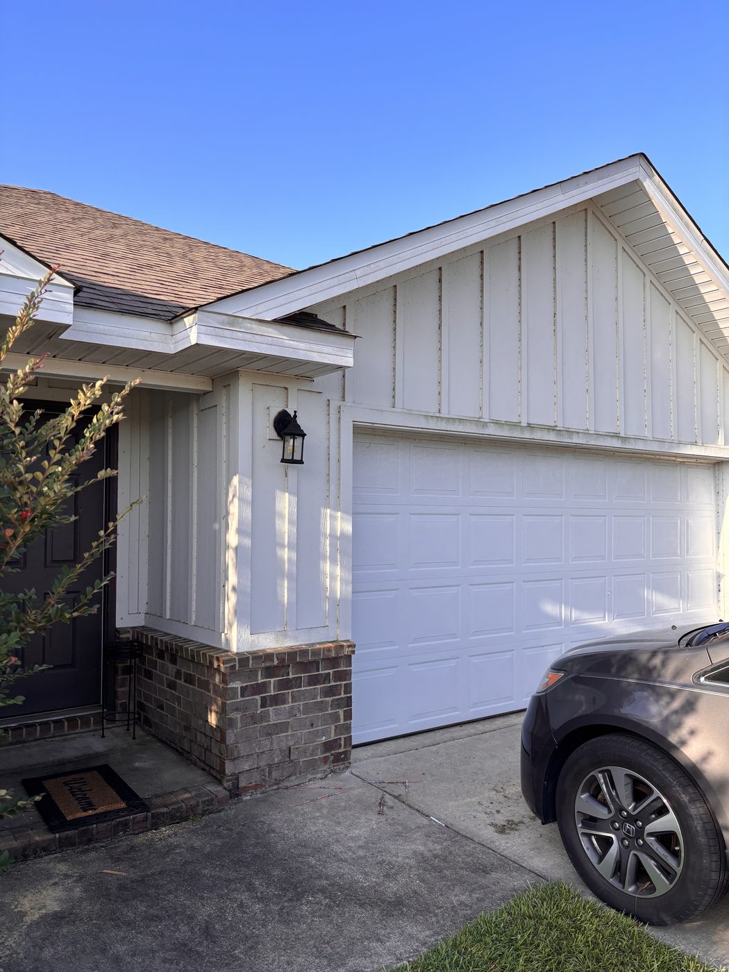 Algae on white siding before soft washing in Daphne, AL