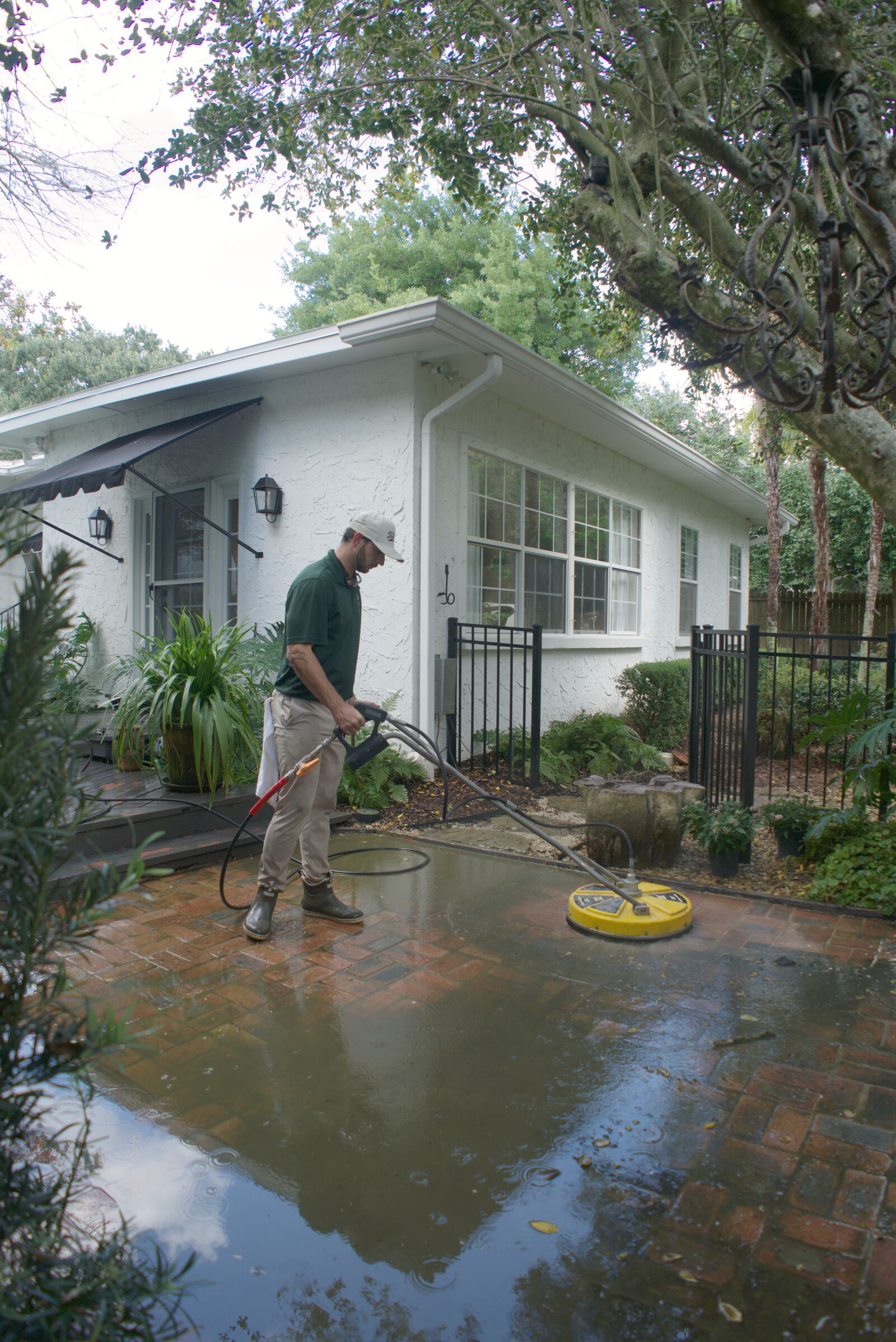 Tailored Pro Wash technician surface cleaning a brick patio at a Fairhope, AL home