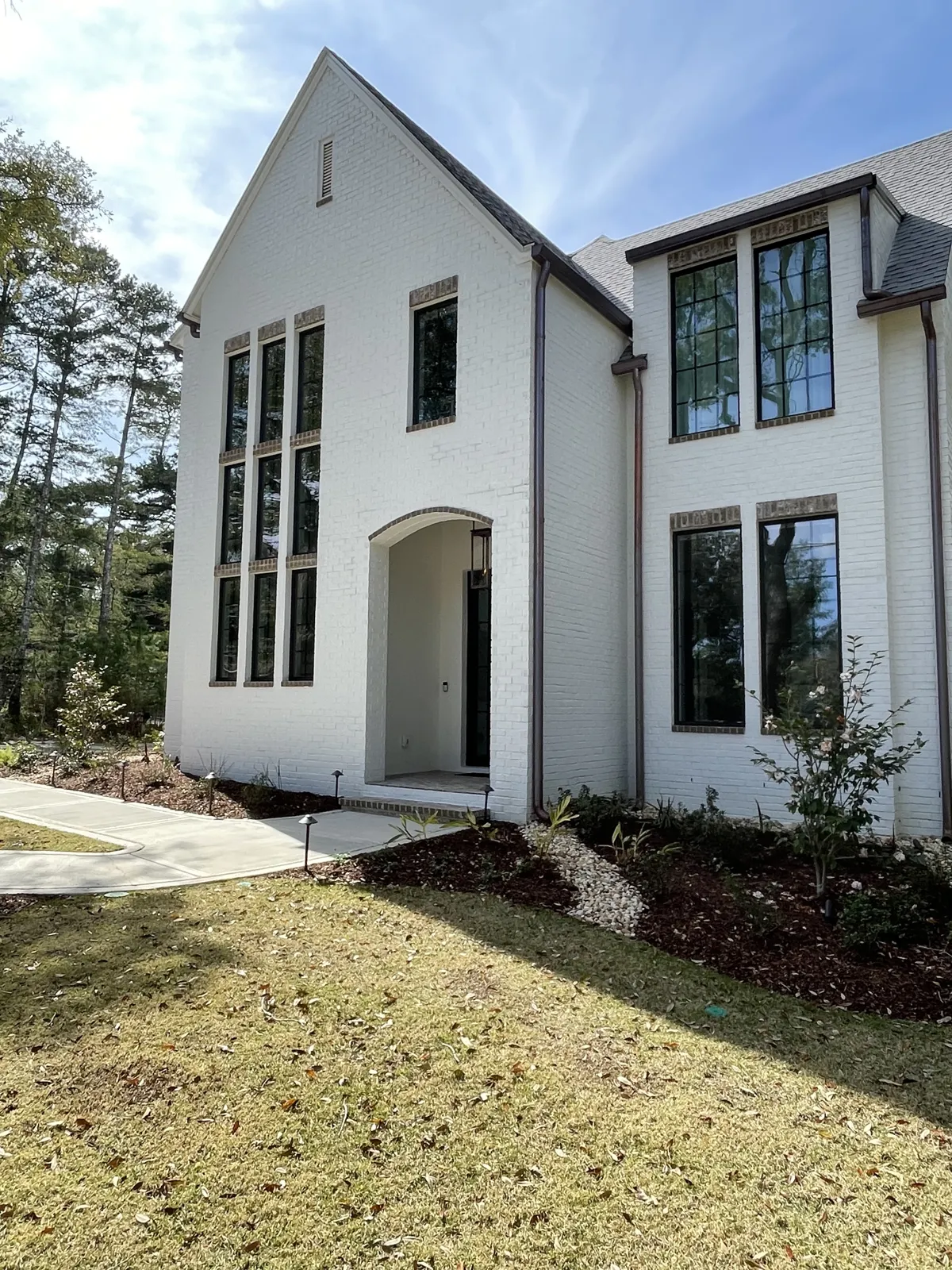 After: dark-framed exterior windows cleaned on a white brick home in Fairhope, AL