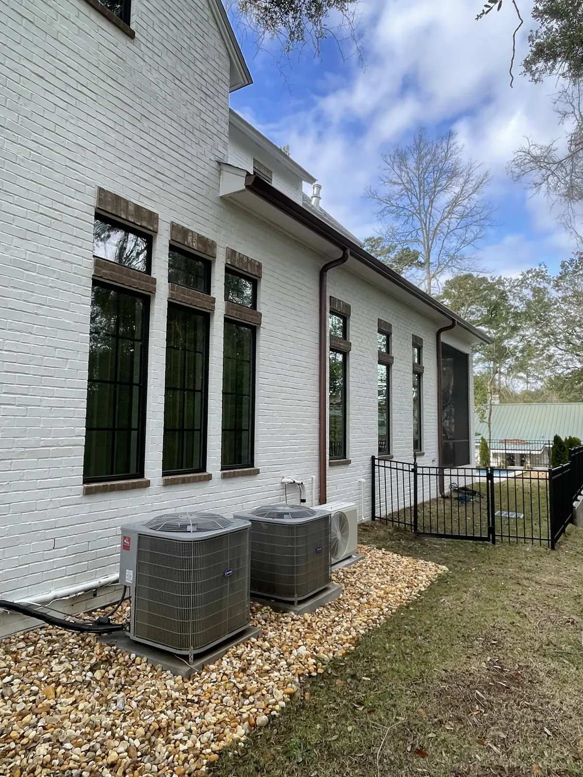 After: exterior windows cleaned on the side of a white brick home in Fairhope, AL